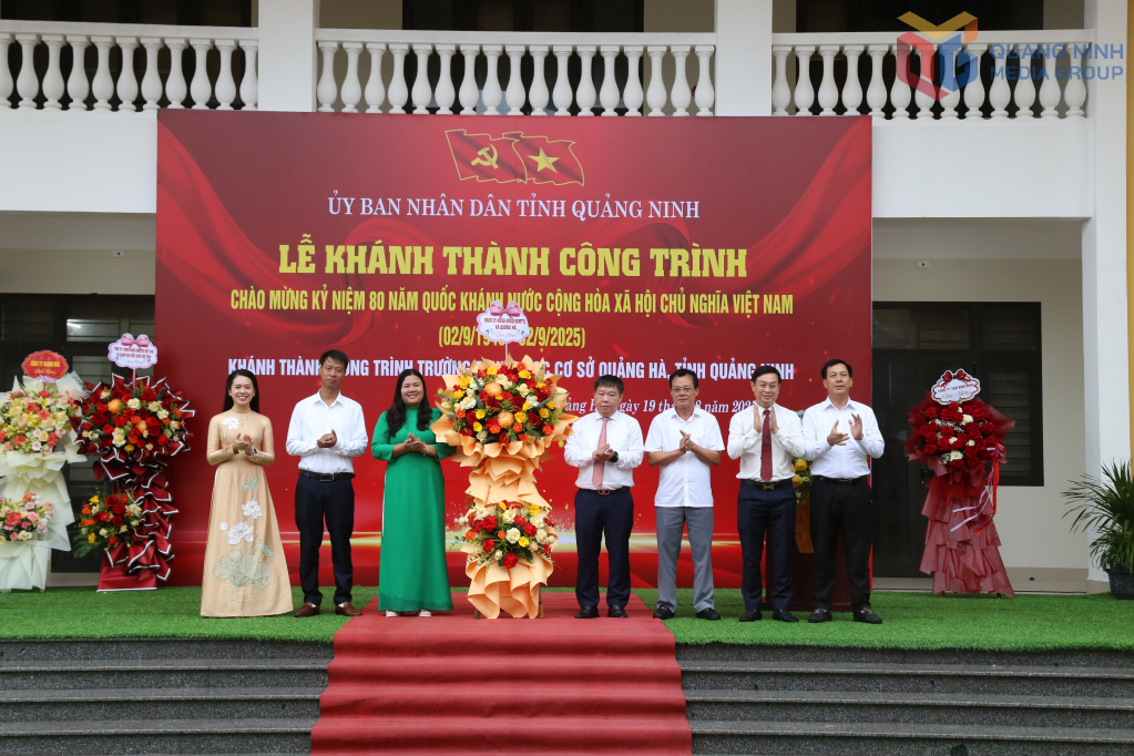 Các đại biểu tặng hoa chúc mừng nhà trường